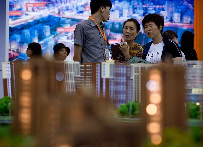 在北京房地产投资展览会上,人们观看展示的住房模型。(美联社)